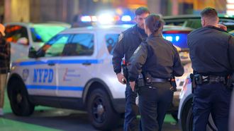 A group of police officers standing in front of a nypd car.