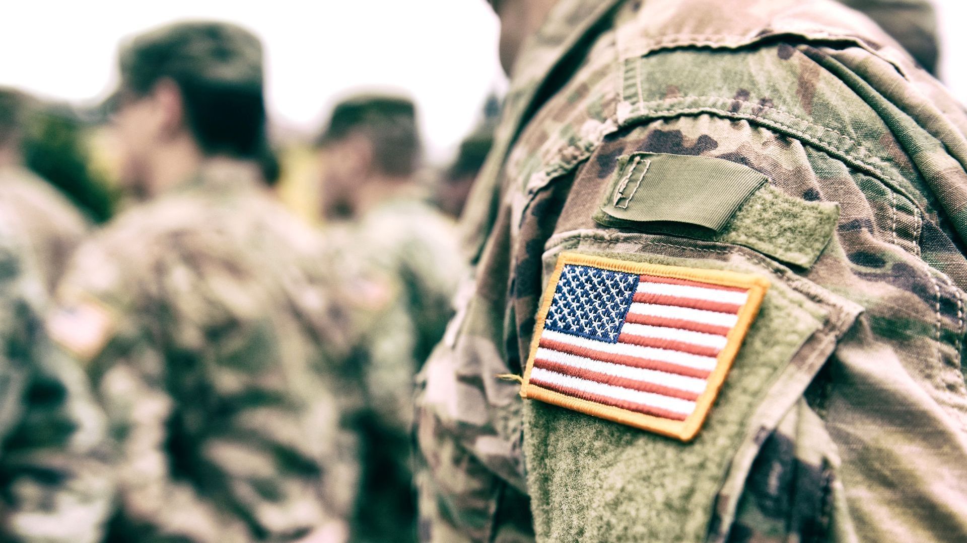 A close up of a soldier 's shoulder with an american flag patch.