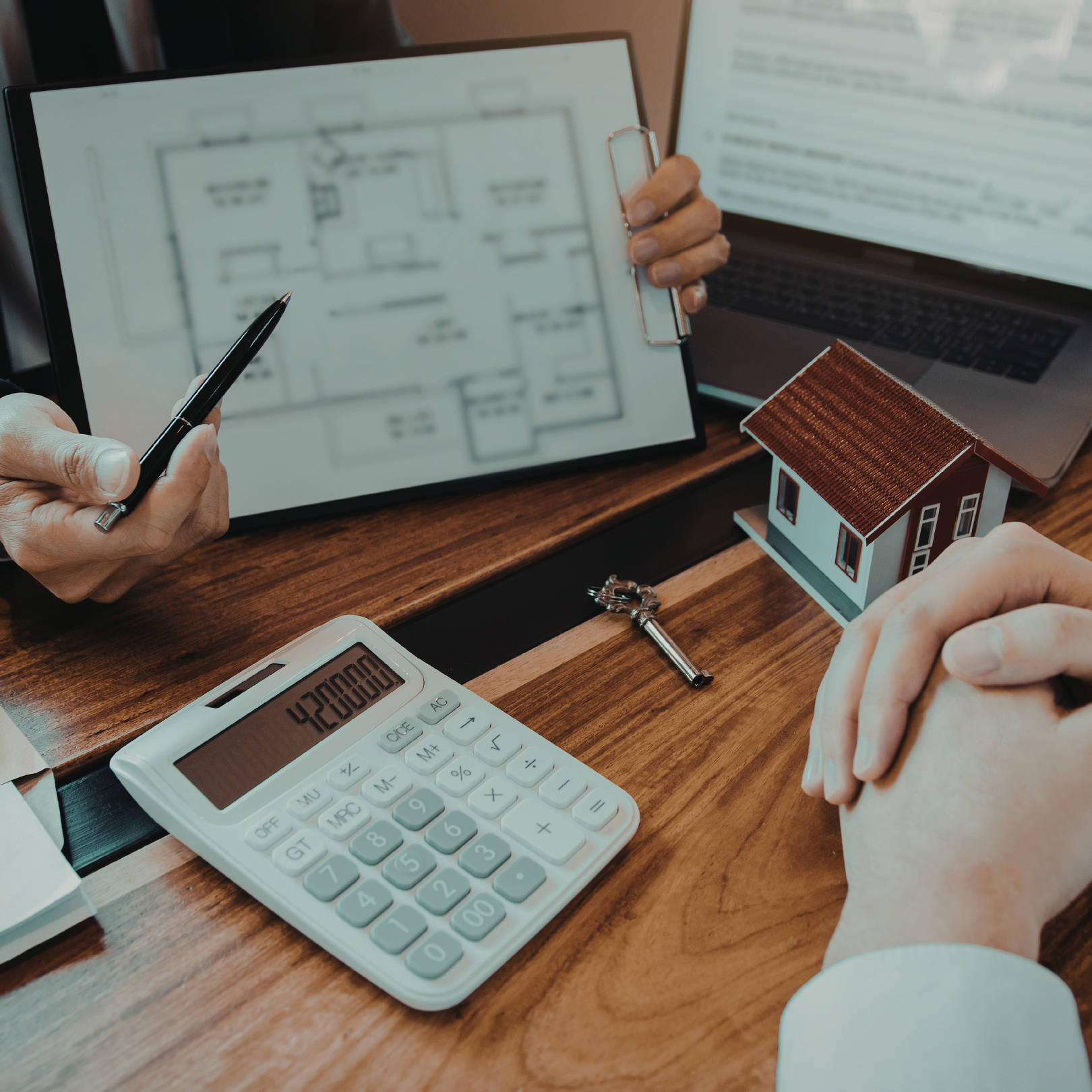 Two people reviewing a document, a gavel and laptop on the desk.