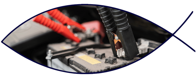 Blue car-shaped keychains displayed on the front desk, with a BMW mug and a Christian fish symbol sign in the background.