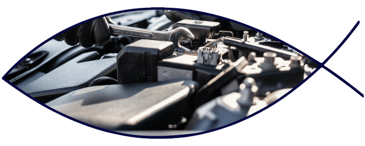 Blue car-shaped keychains displayed on the front desk, with a BMW mug and a Christian fish symbol sign in the background.