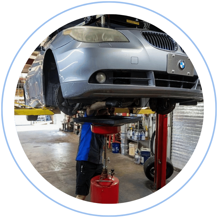 Oil change service with vehicle lifted and fluid draining