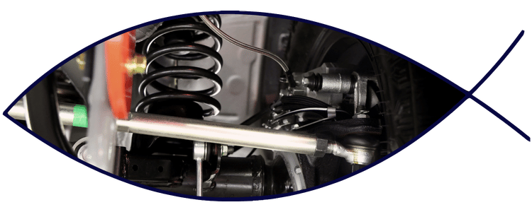 Blue car-shaped keychains displayed on the front desk, with a BMW mug and a Christian fish symbol sign in the background.