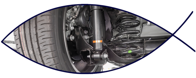 Blue car-shaped keychains displayed on the front desk, with a BMW mug and a Christian fish symbol sign in the background.