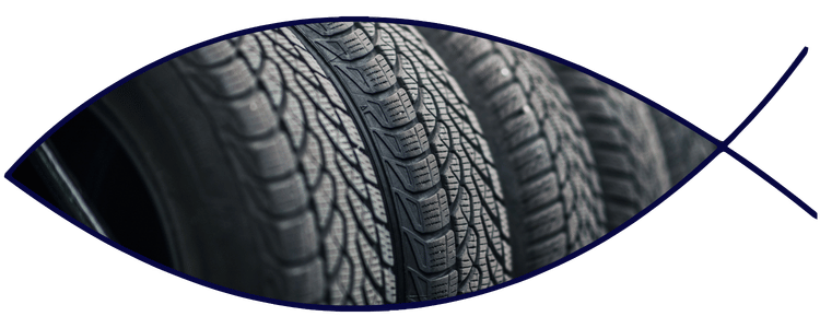 Blue car-shaped keychains displayed on the front desk, with a BMW mug and a Christian fish symbol sign in the background.