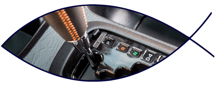 Blue car-shaped keychains displayed on the front desk, with a BMW mug and a Christian fish symbol sign in the background.