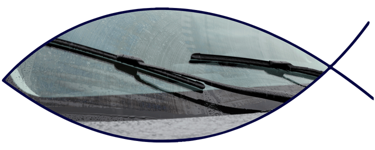 Blue car-shaped keychains displayed on the front desk, with a BMW mug and a Christian fish symbol sign in the background.