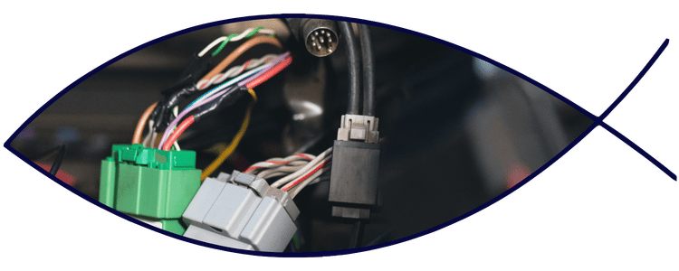 Blue car-shaped keychains displayed on the front desk, with a BMW mug and a Christian fish symbol sign in the background.