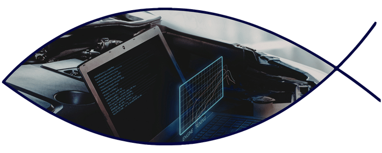 Blue car-shaped keychains displayed on the front desk, with a BMW mug and a Christian fish symbol sign in the background.