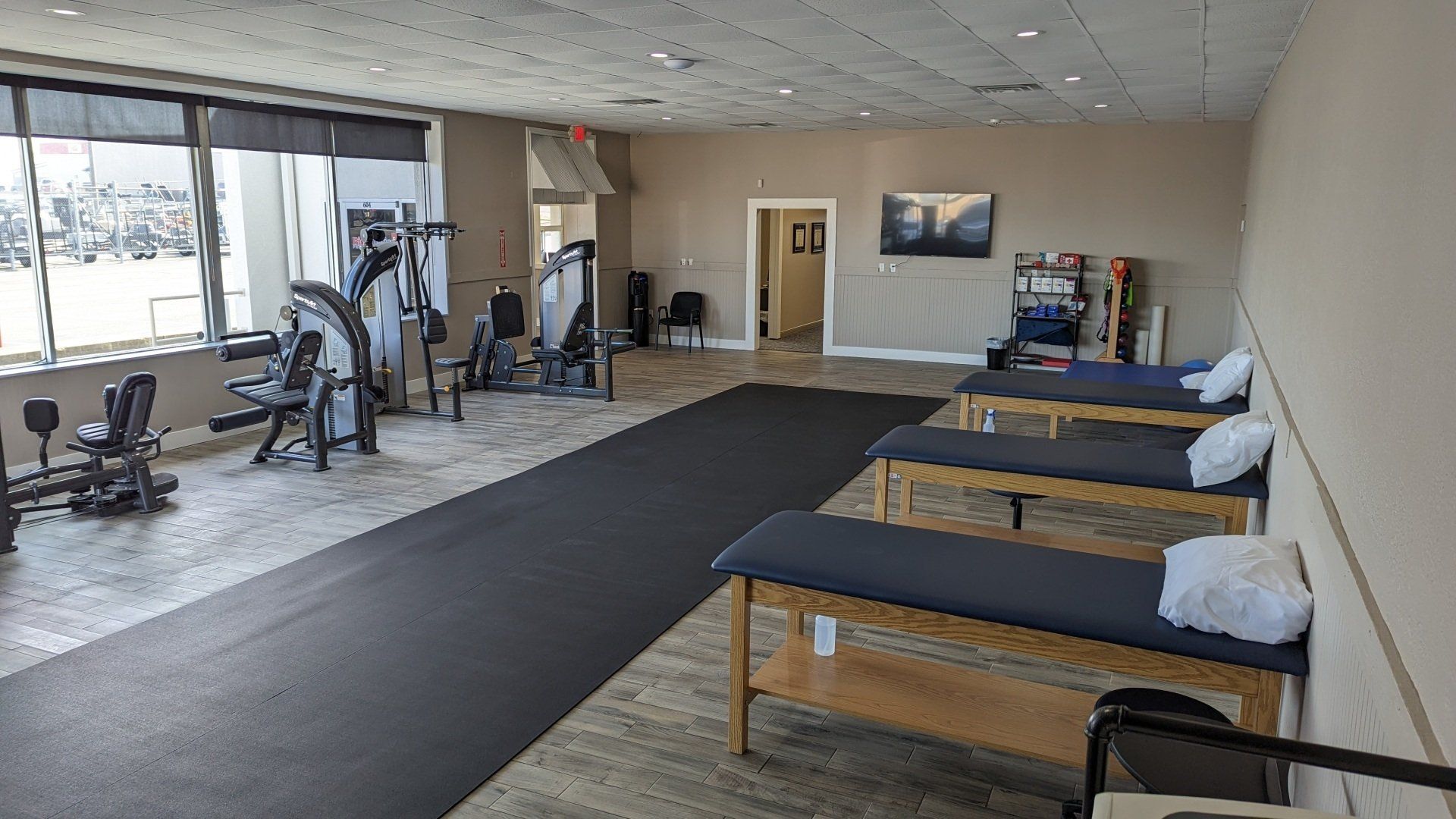A gym with a lot of tables and exercise equipment.