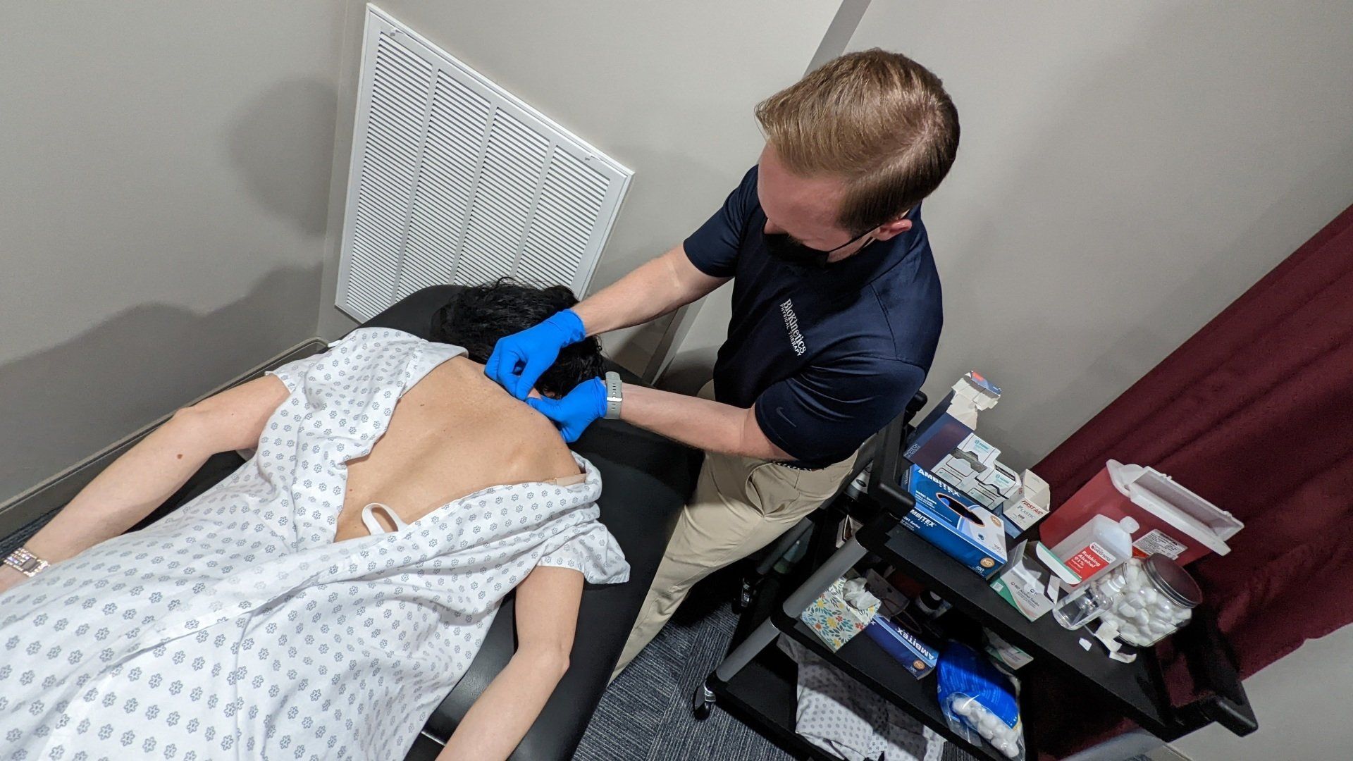 A man is giving a woman a massage on her back.