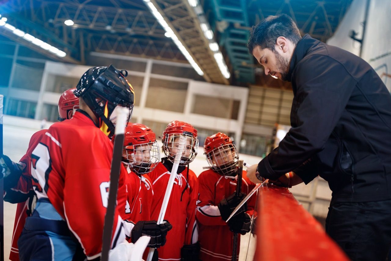 Hockey coaching showing youth hockey players a play
