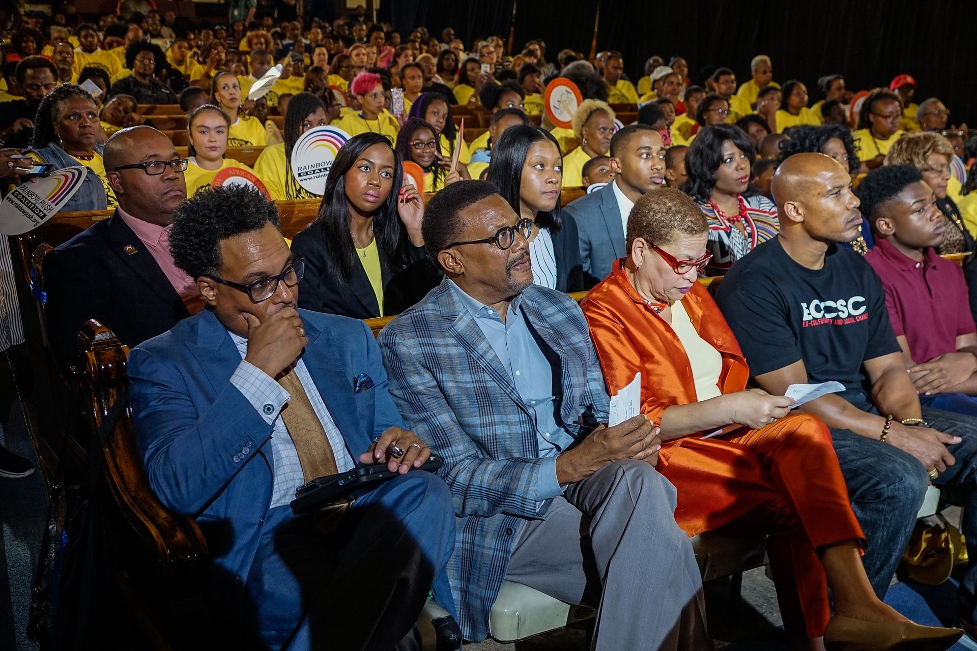 A large group of people are sitting in a theater watching a show.