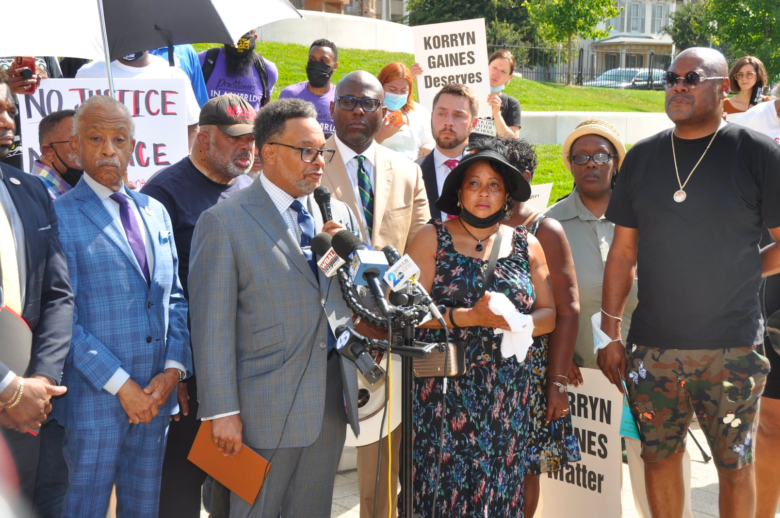 A group of people standing in front of a sign that says no justice no peace