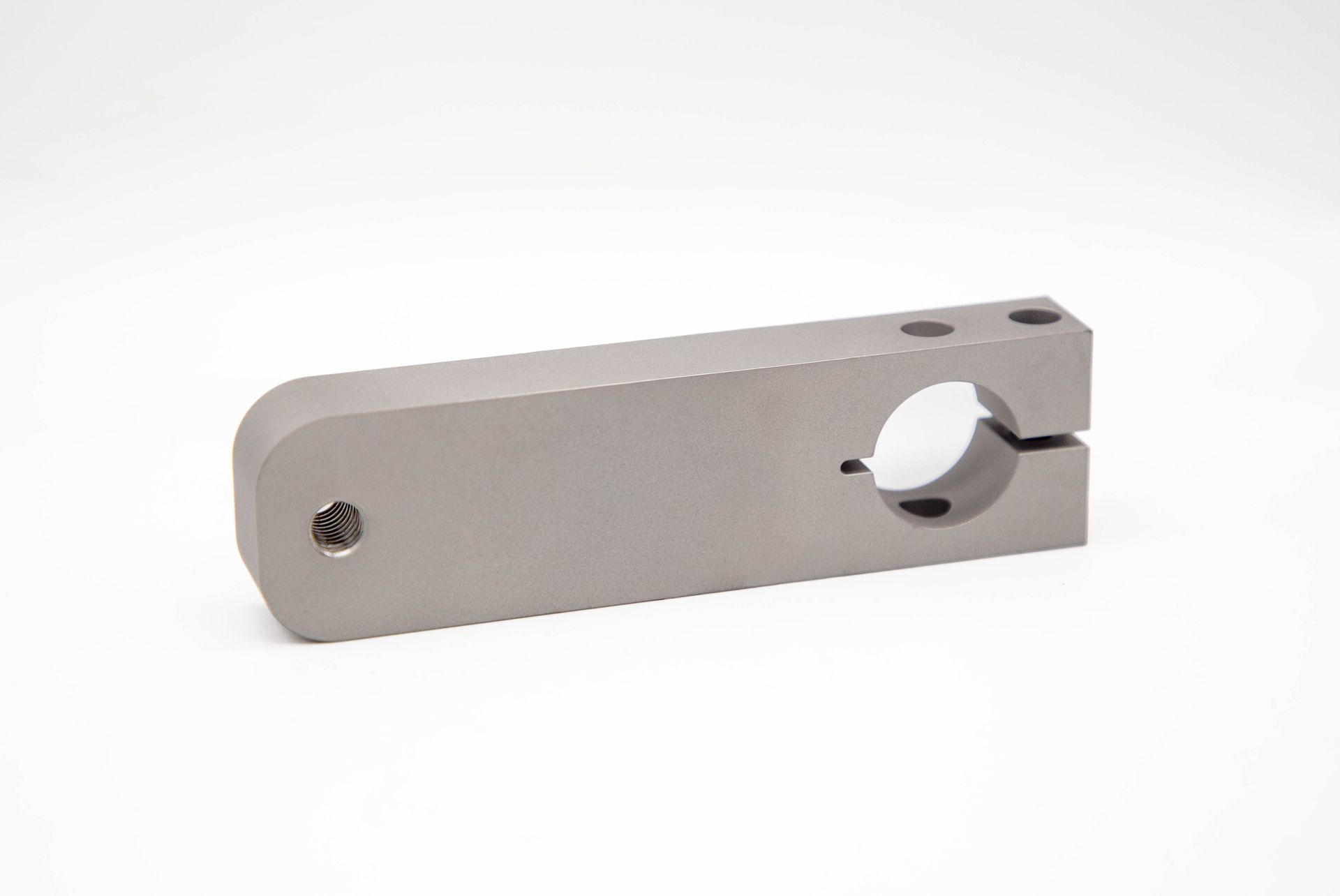 Silver metal clamp with a cylindrical opening and bolt holes.