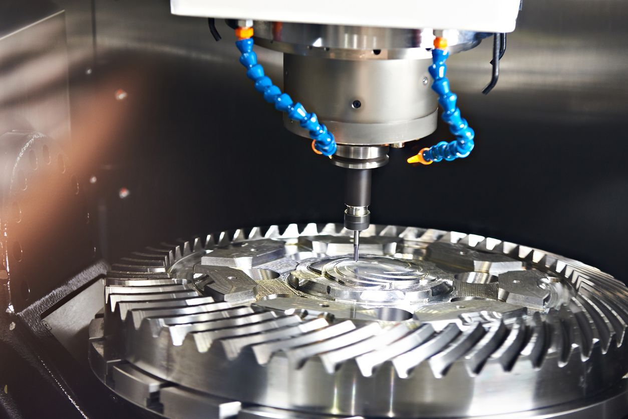 CNC machine milling a metal gear with coolant hoses.