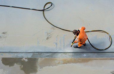 Man Sandblasting Concrete Surface — Linn Grove, IA — Hare Painting & Sandblasting