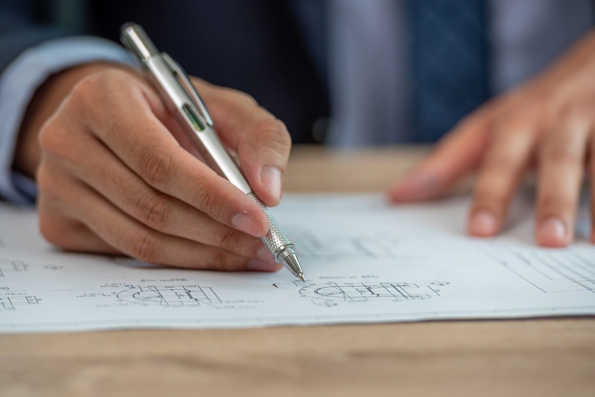 A person is writing on a piece of paper with a pen.