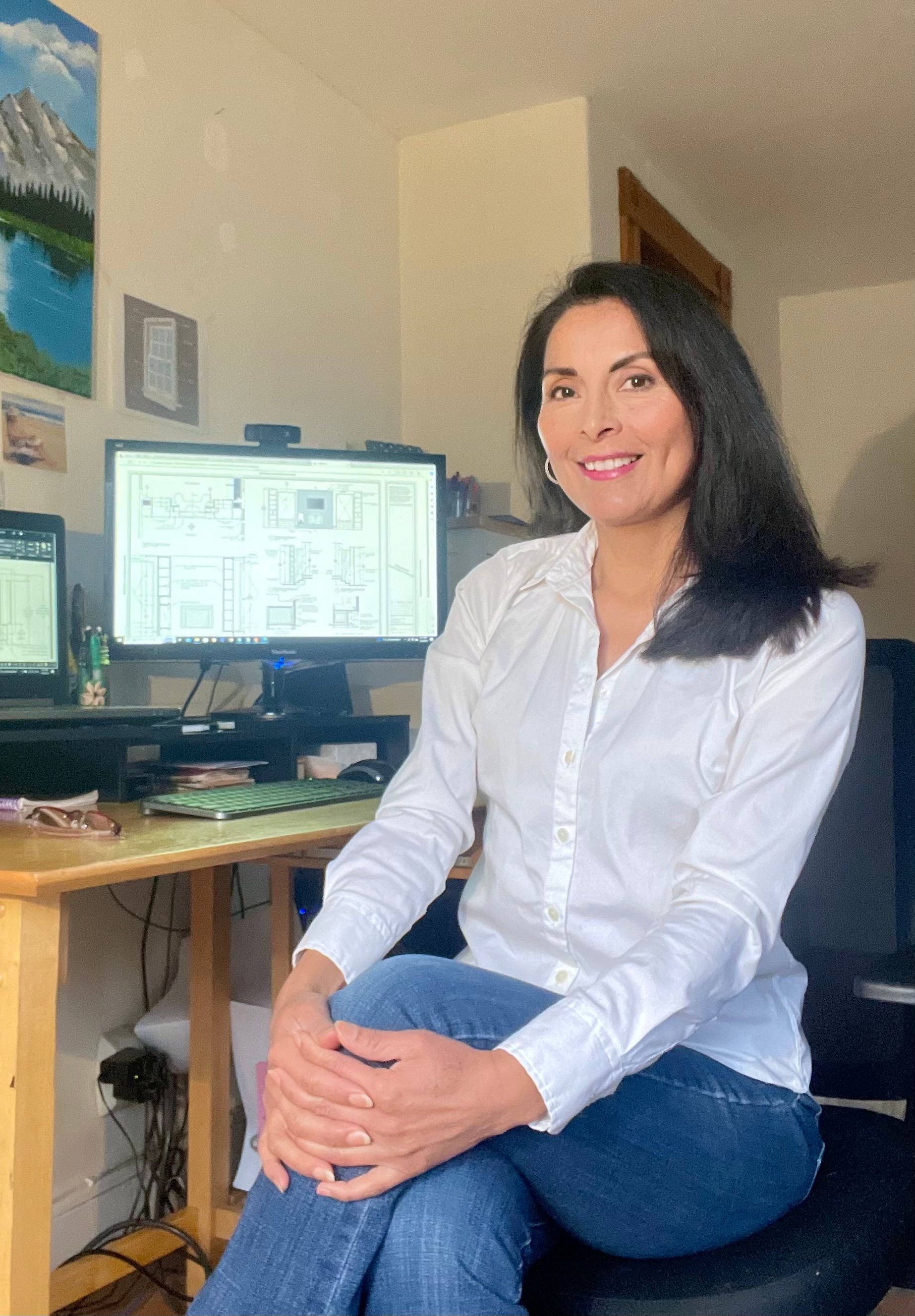 A group of construction workers are standing around a table with a hard hat.