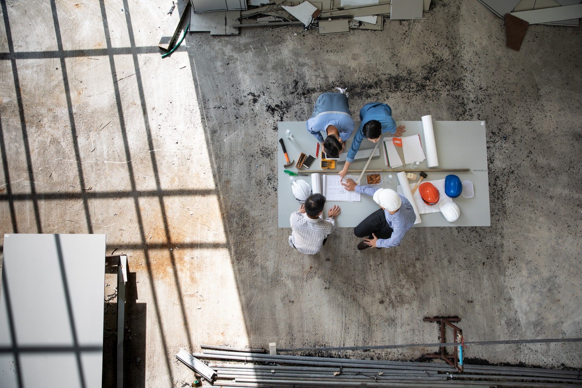 An aerial view of a group of construction workers sitting around a table.