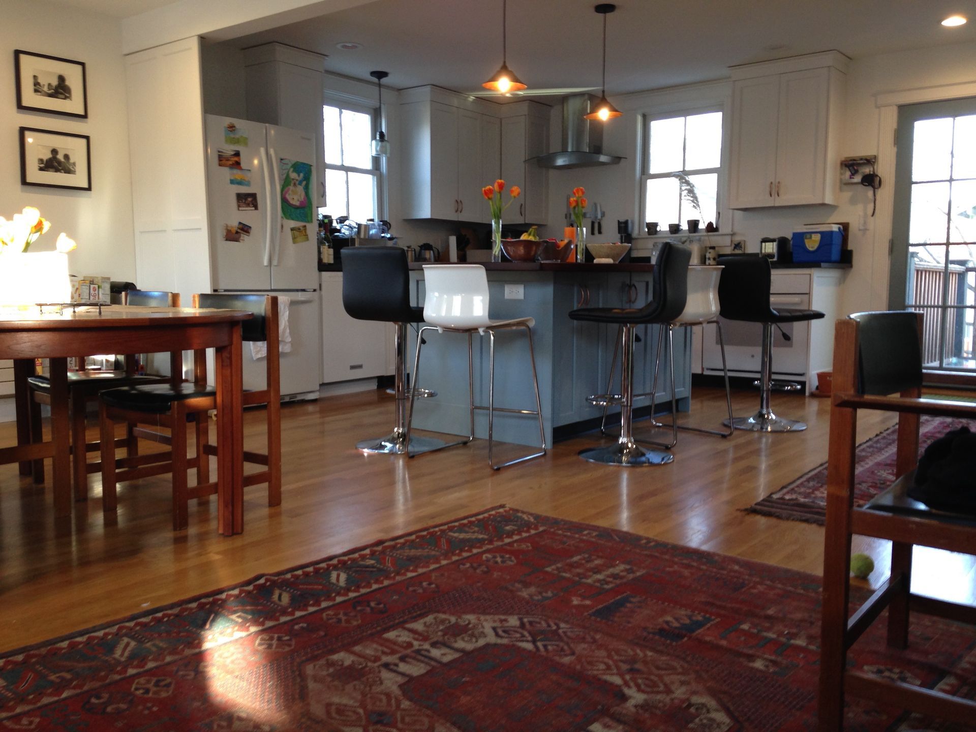 A living room with a table and chairs and a rug