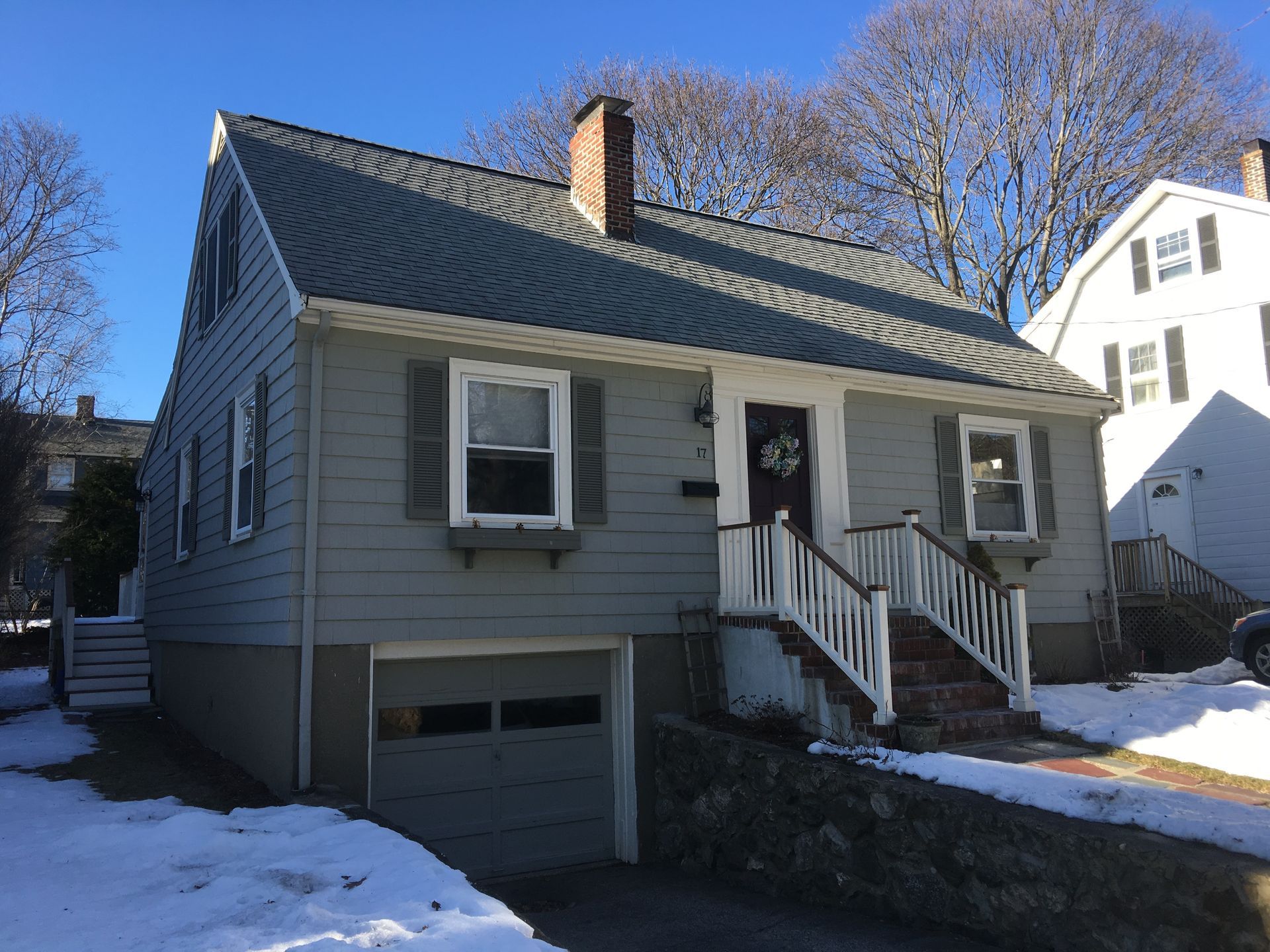 A house with a garage and stairs in the snow