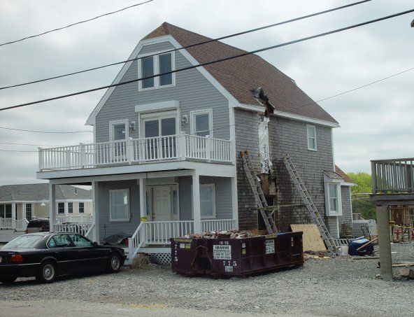 A large house with a purple dumpster in front of it