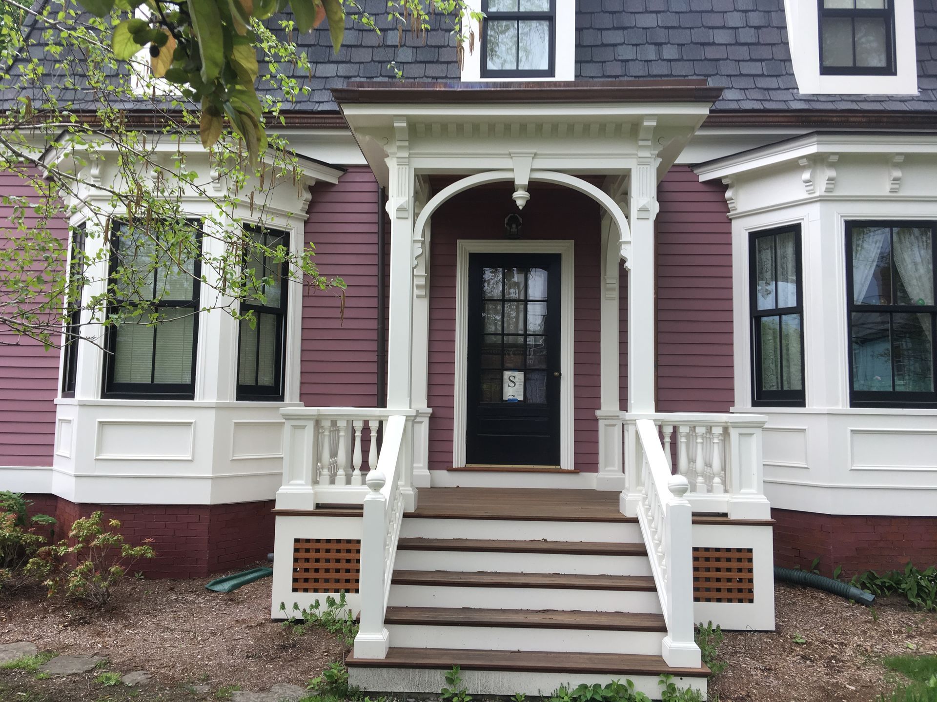 A pink and white house with a porch and stairs