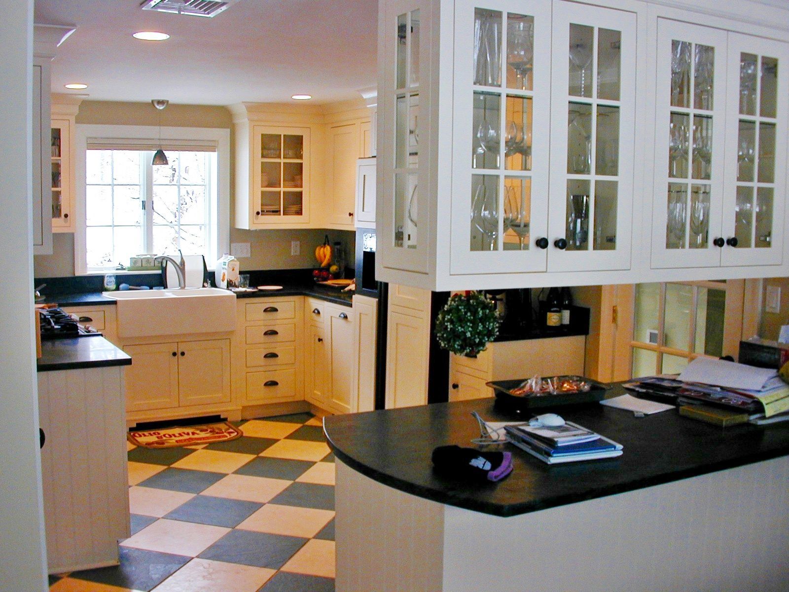 A kitchen with a checkered floor and white cabinets