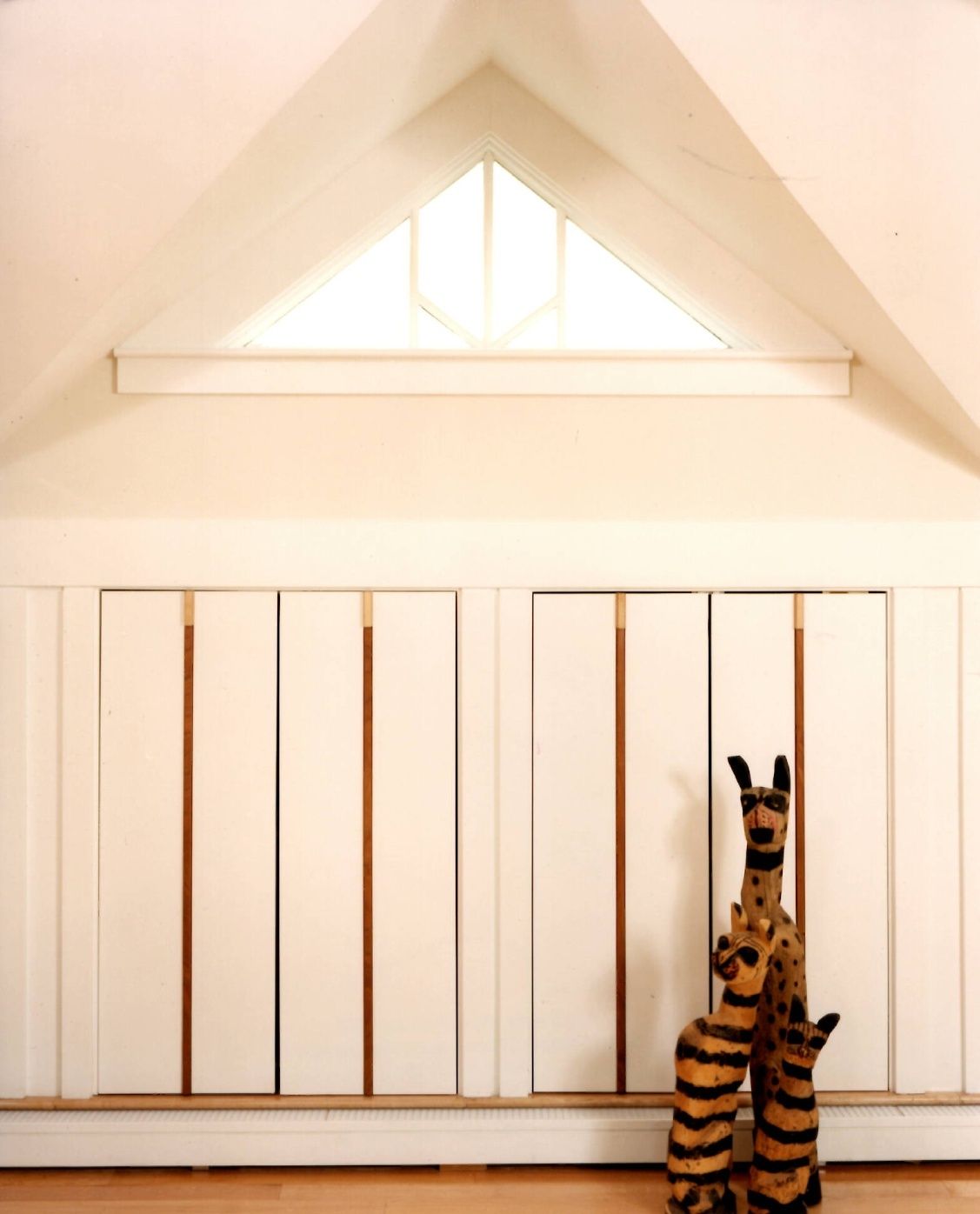 A stuffed animal is sitting in front of a window in a room.