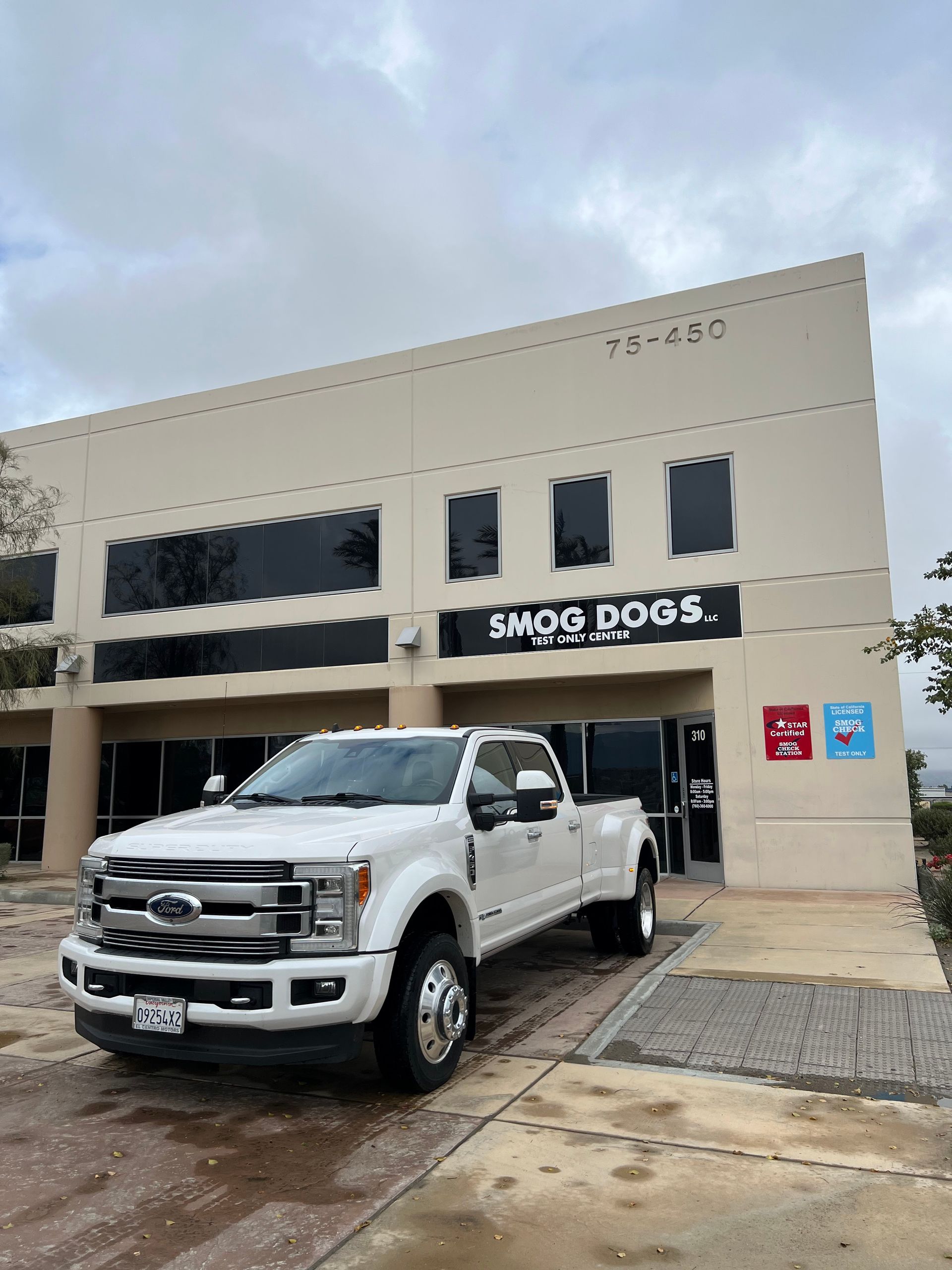 A white truck is parked in front of a building.