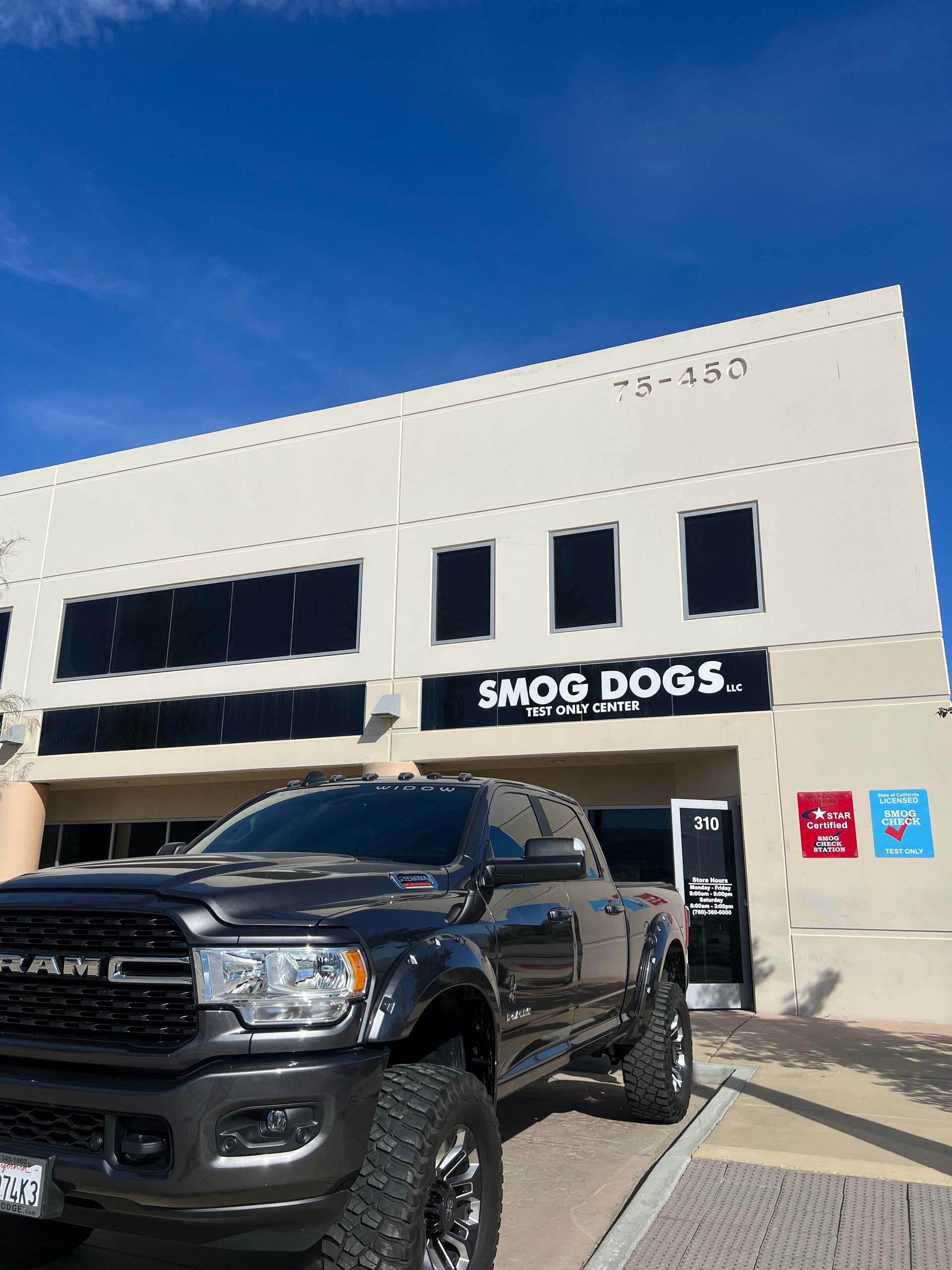 A truck is parked in front of a building that says smog doors