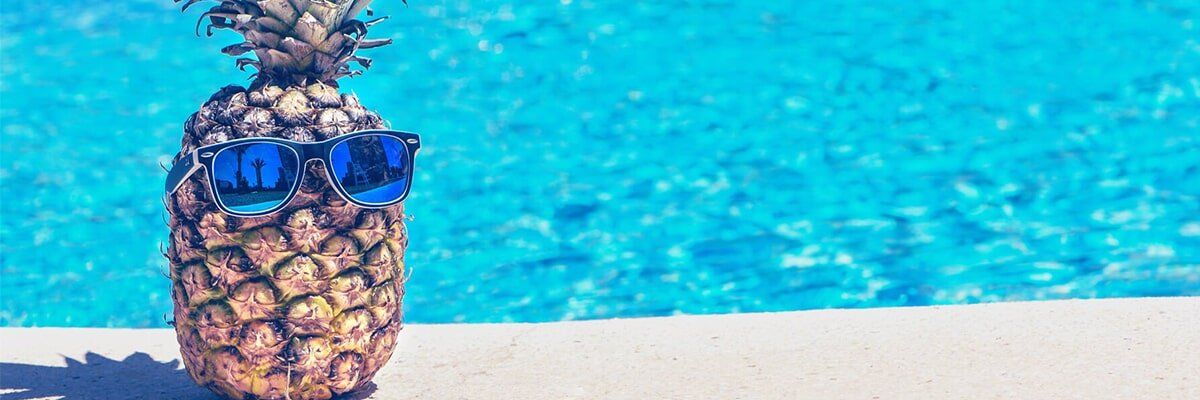 A pineapple is sitting on the edge of a swimming pool-Pool builder in Bundaberg