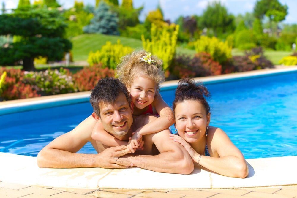 Family by the swimming pool in Bundaberg - Aqualine Pools Bundaberg
