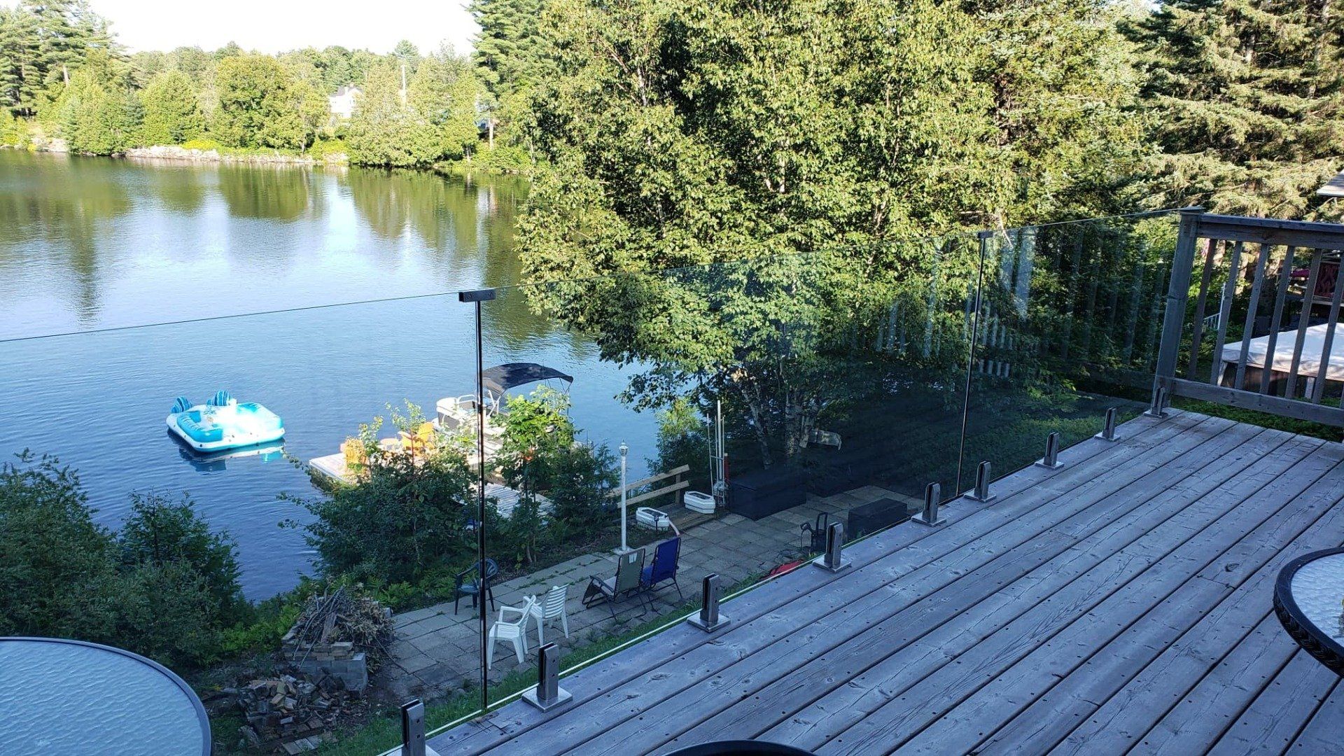 Une vue sur un lac depuis une terrasse avec un bateau dans l'eau.