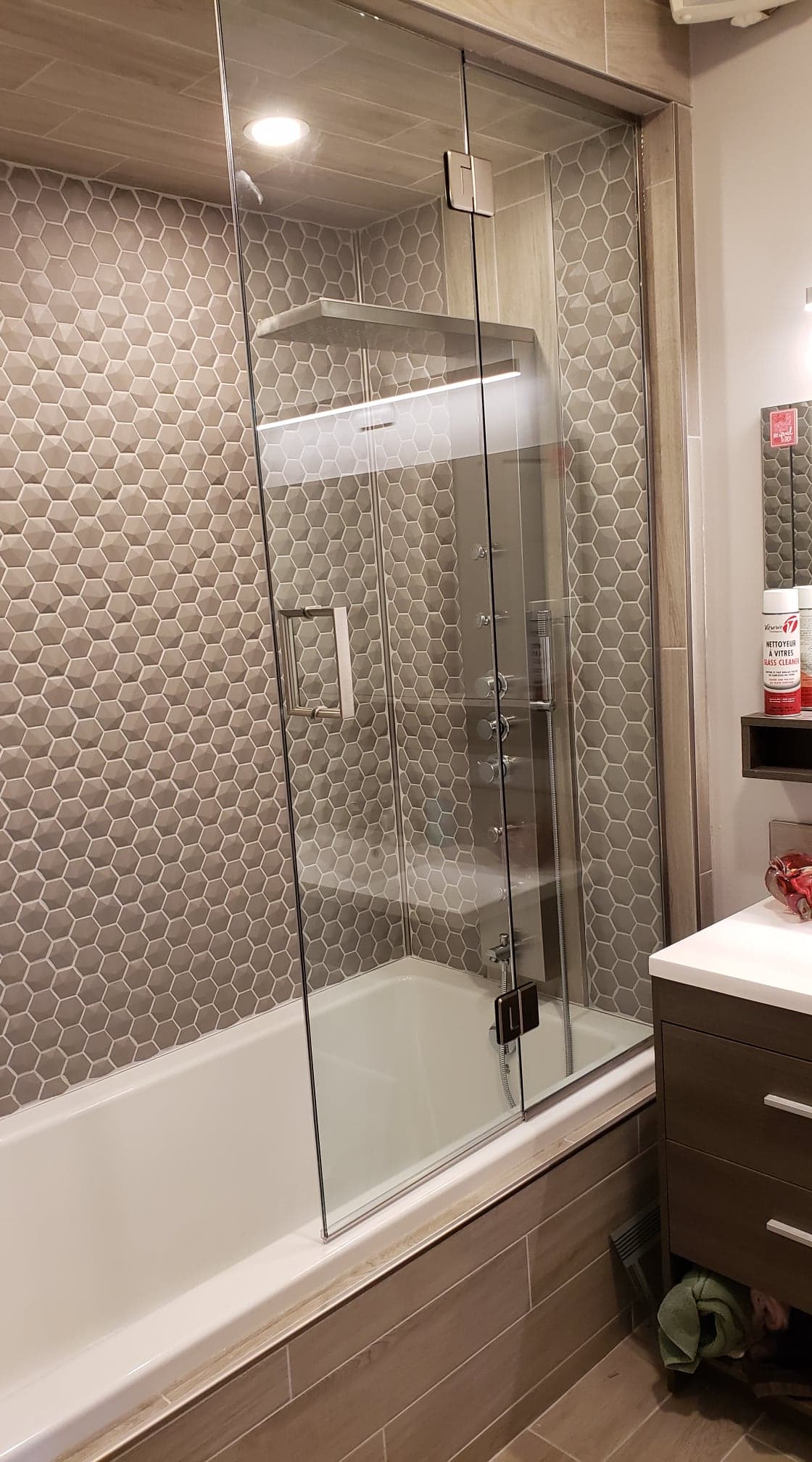 Une salle de bain avec baignoire, lavabo, miroir et cabine de douche.