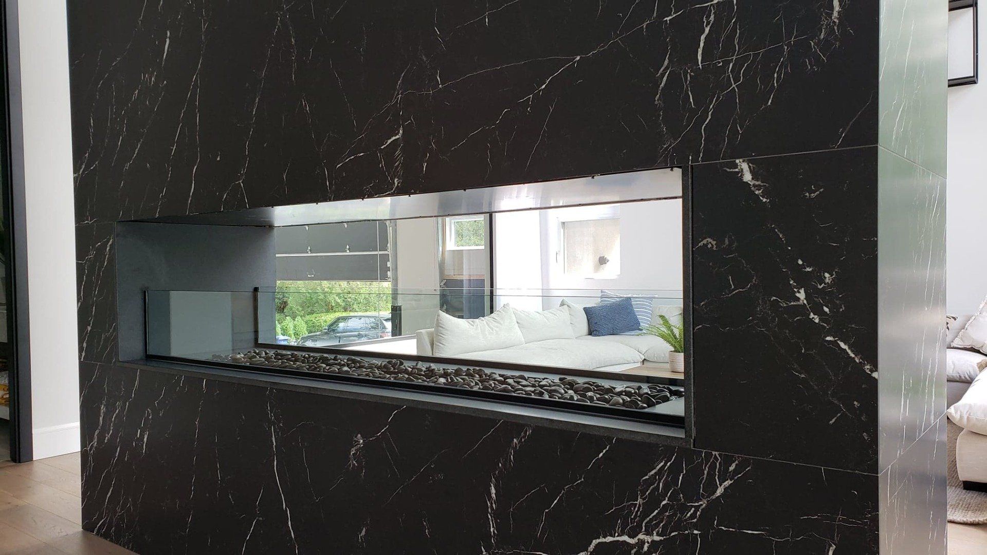 Une cheminée avec un miroir au milieu dans un salon.