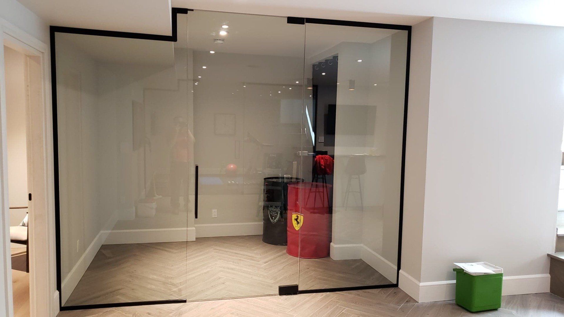 Une pièce avec des portes coulissantes en verre et une exposition de Ferrari rouge