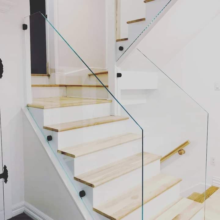 Un escalier avec une rampe en verre et des marches en bois