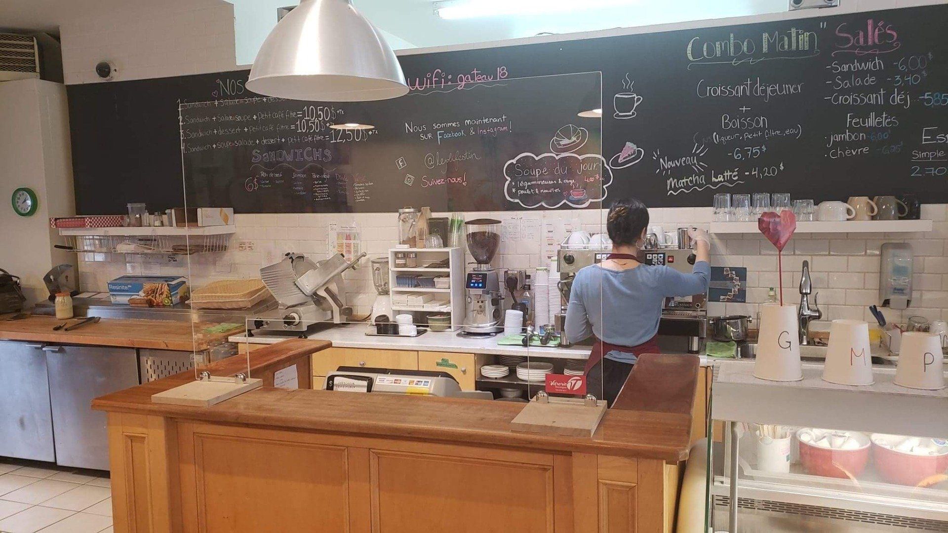 Un homme se tient derrière un comptoir dans une boulangerie.