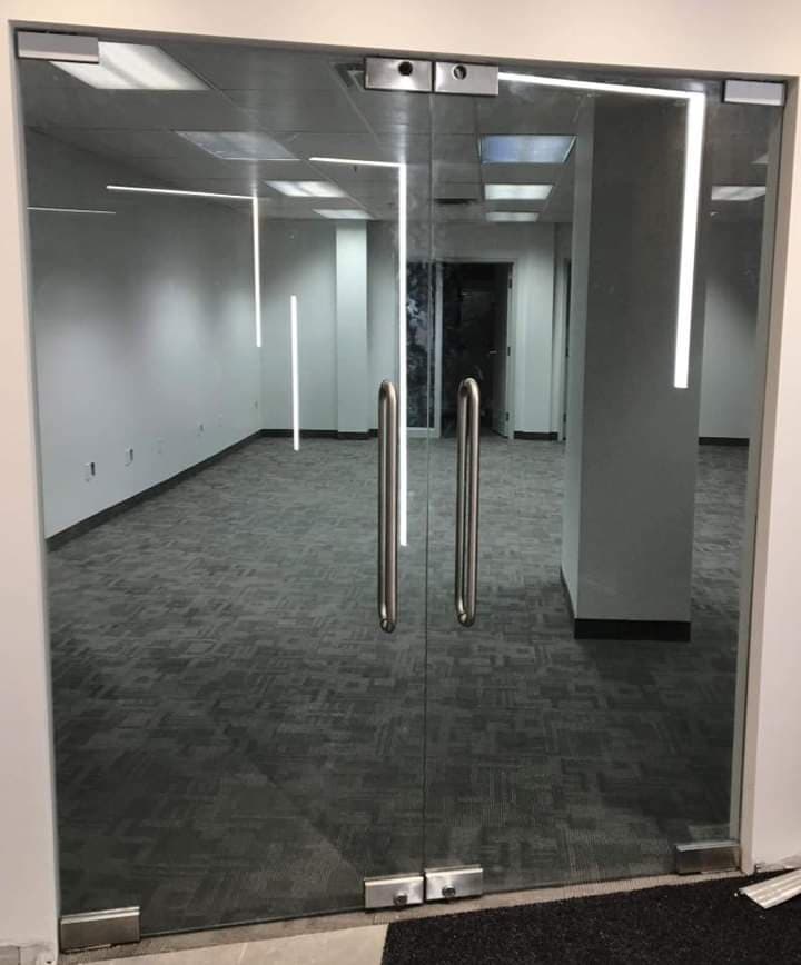 Une pièce vide avec une porte vitrée et une poignée en acier inoxydable