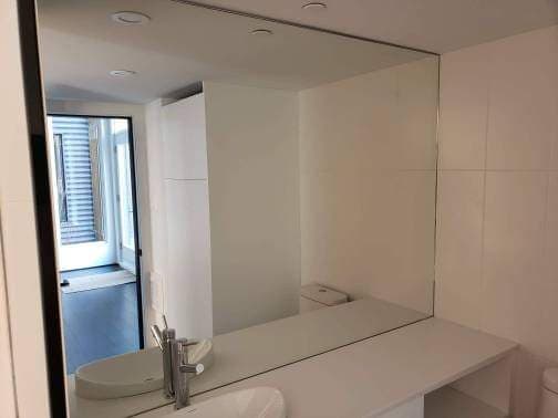 Une salle de bain avec un lavabo et un grand miroir.