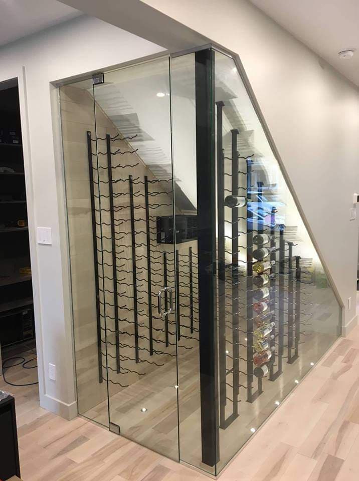 Il y a une cave à vin sous l'escalier avec une paroi vitrée.
