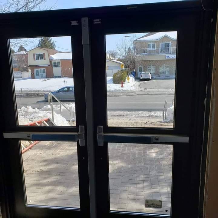 A pair of doors with a view of a snowy street.