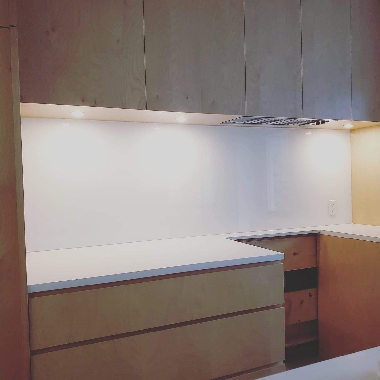 Une cuisine avec des armoires en bois et un comptoir blanc