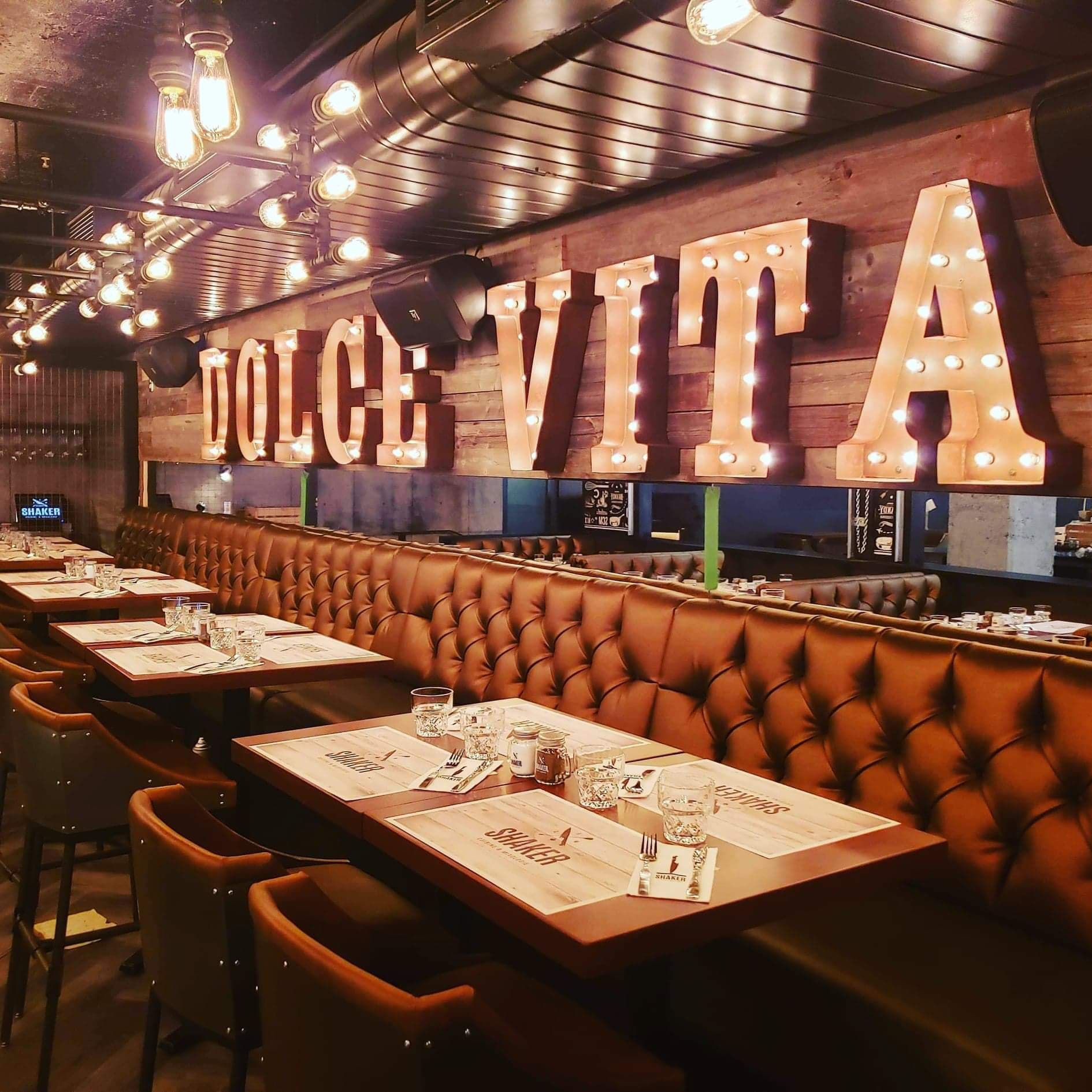 Un restaurant avec des tables et des chaises et un panneau indiquant dolce vita