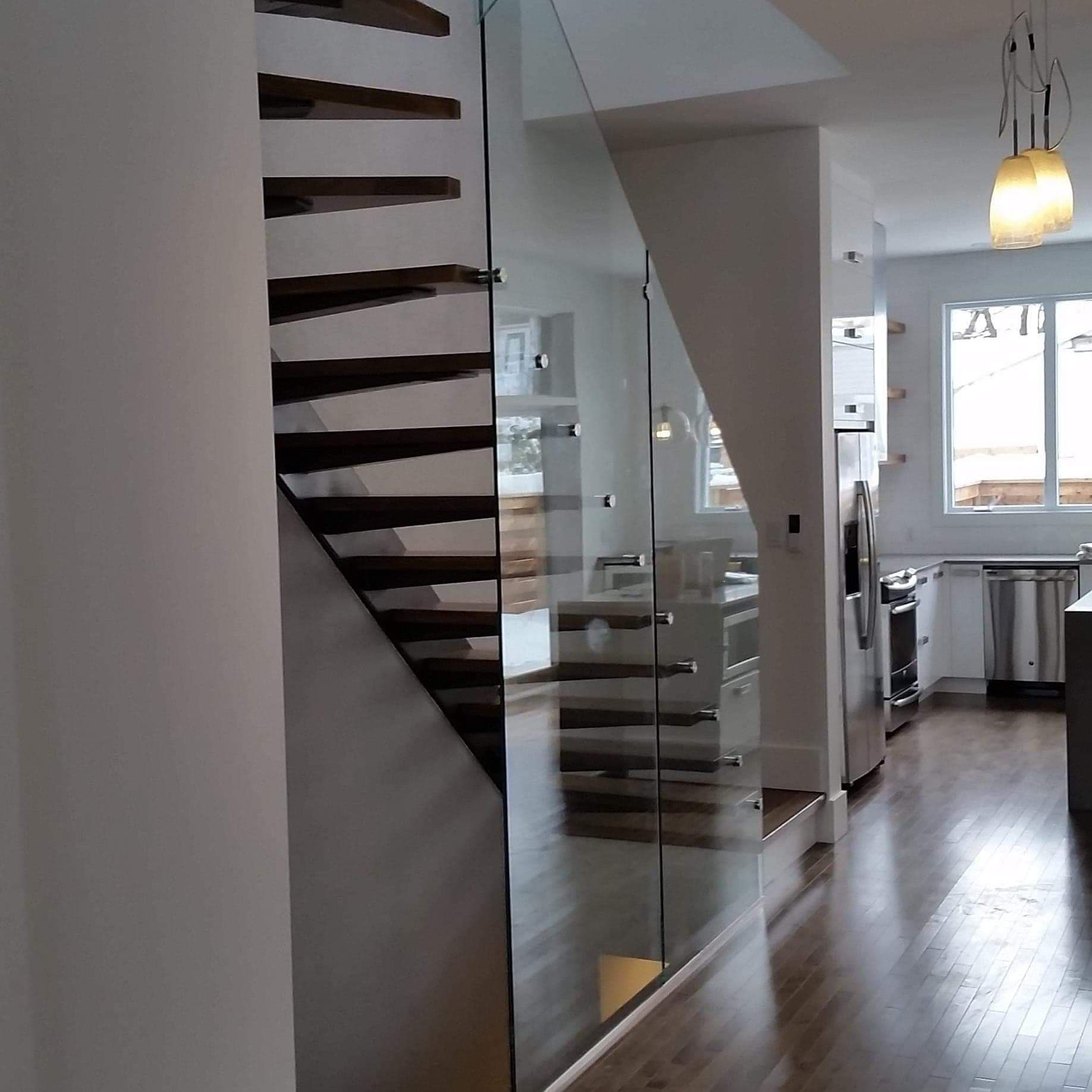 Un escalier avec une rampe en verre dans une cuisine