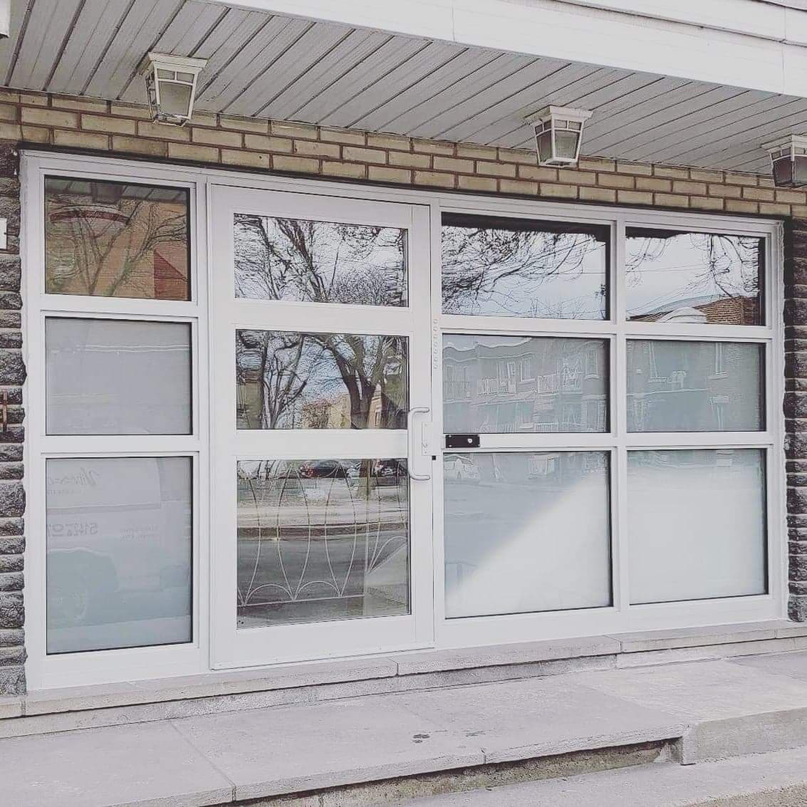 A brick building with a white door and windows