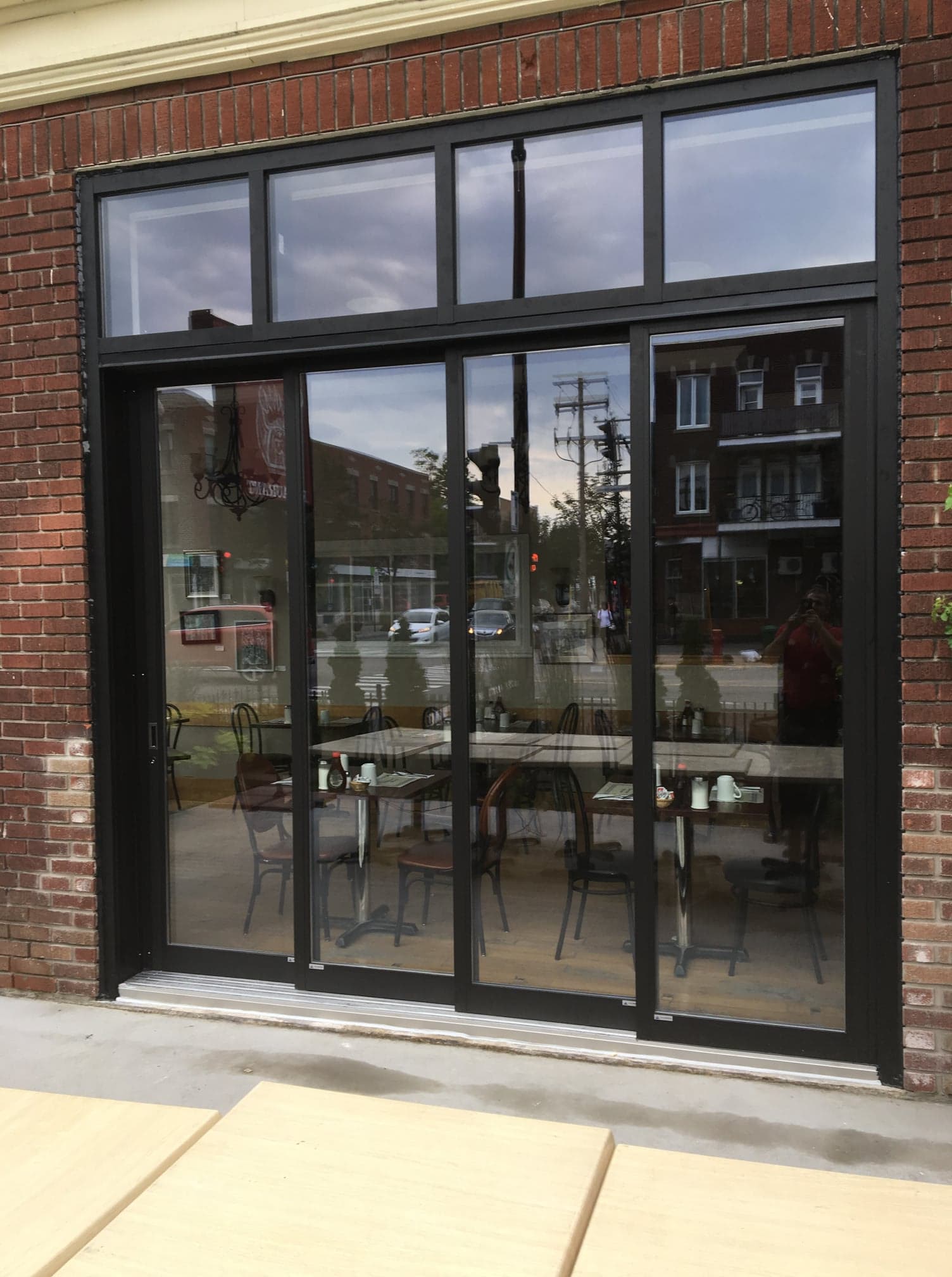 A brick building with a large window and sliding glass doors