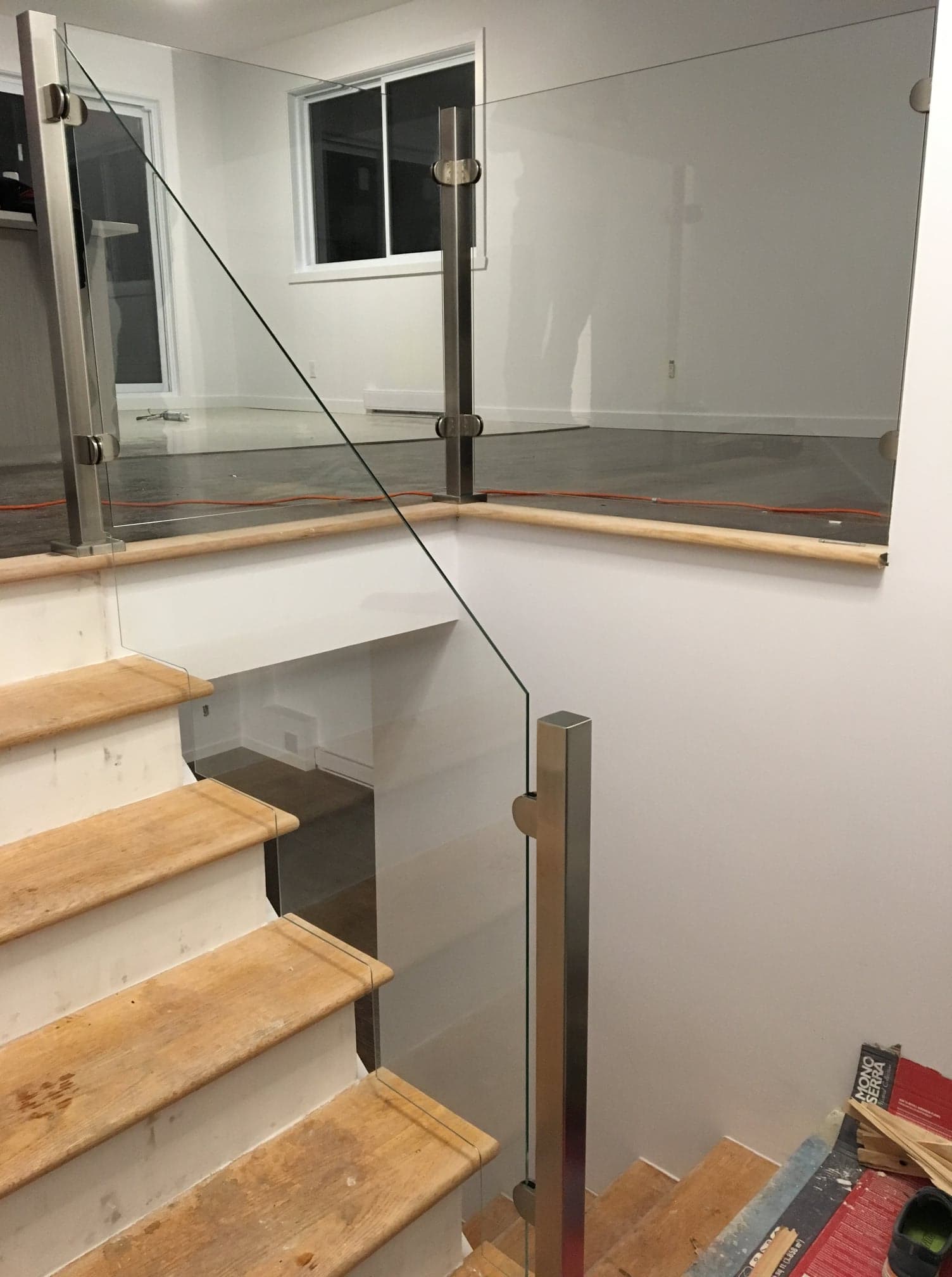 Un escalier avec des marches en bois et une rampe en verre.